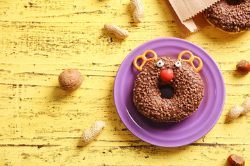 Funny decorated donut on plate