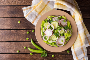 Fresh vegetable salad on wooden table.