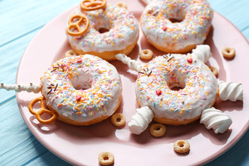 Funny decorated donuts on plate