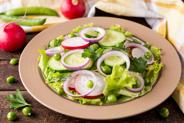 Fresh vegetable salad on wooden table.