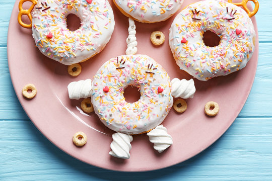 Funny decorated donuts on plate