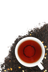 Dried tea leaves and cup of aromatic drink on white background