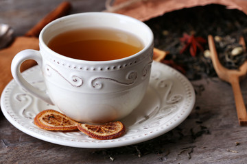 Cup of tea with dried leaves on wooden table