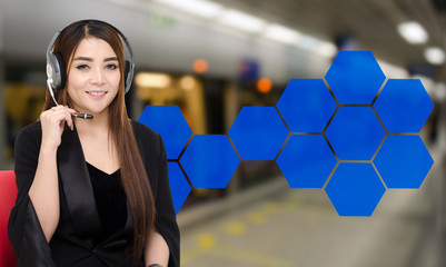 portrait of asian woman in suit support phone operator or call center in headset sitting on red...