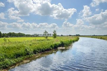Poster   Canalised river and cloudy sky in a Dutch Landscape in the province of Drenthe, The Netherlands.  © defotoberg