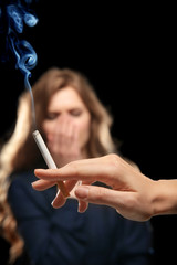 Obraz premium Woman covering face from cigarette smoke. Passive smoking concept