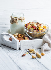 healthy Breakfast with milk in the jar and muesli with nuts