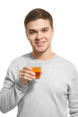 Fototapeta premium Young man drinking juice on white background