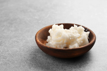 Wooden bowl with fresh coconut oil on table