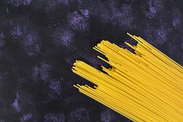 Dry pasta background. Spaghetti pasta on dark background. Flat lay. Top view.