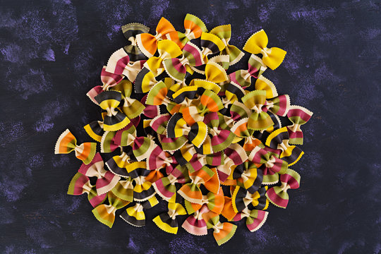 Mixed colorful farfalle pasta. Flat lay. Top view.