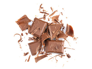 Broken chocolate pieces and shavings on white background
