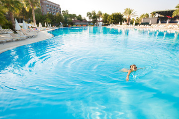 woman swimming on a blue water pool
