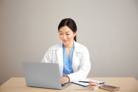 Pretty Dentist Working On Laptop At Workplace