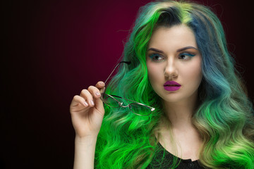 Fototapeta premium She got her style. Studio portrait of a beautiful green haired young woman looking away thoughtfully holding her glasses copyspace on the side