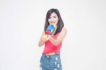 Thailand New year concept. Focus on toy gun. Young happy beauty Asian woman holding plastic water gun at Songkran festival, Thailand. Isolated on white background.