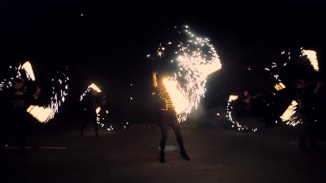 Girls spin fire sparkling fireworks and dancing. Fire show performance