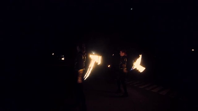 Girls spin fire sparkling fireworks and dancing. Fire show performance