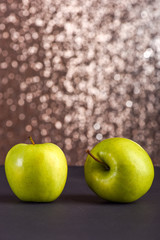fresh green apples on grey table, sparkling background