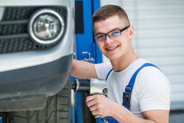 Professional car mechanic working on wheels