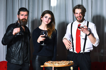 Happy and serious friends toasting glasses over pizza