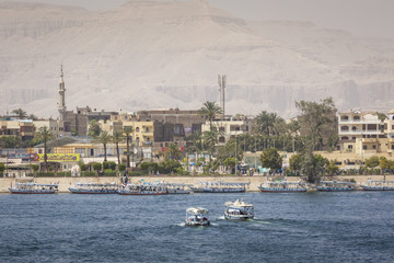 Wooden boats carrying passengers docked along the Nile River in Aswan, Egypt, North Africa