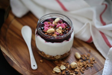Homemade granola with nuts, jam and yogurt