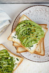 Toast with avocado, feta cheese, herbs and sesame seeds. Healthy eating and wholesome Breakfast