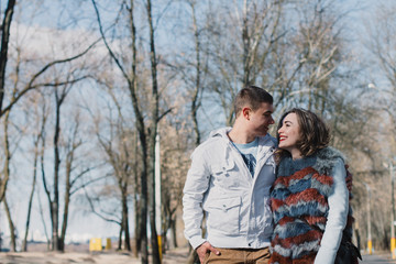 Fototapeta premium Happy couple in love hugging and sharing emotions, holding hands walking in the park