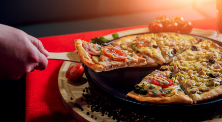 A slice of pizza in his hand. A restaurant.