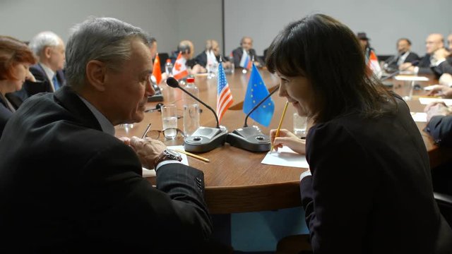Private discussion of two professional politicians at international business forum, conference or summit. Delegates of US and Germany talk about partnership and relations