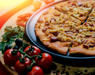 Large hot pizza on the black plate.