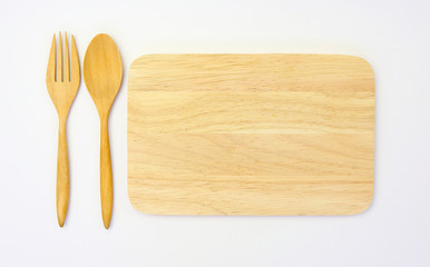 wooden spoon and fork on wooden board against white background