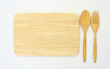 wooden spoon and fork on wooden board against white background