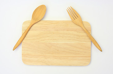 wooden spoon and fork on wooden board against white background