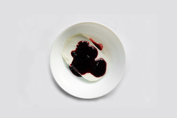 Plate of white ice cream drenched jam. Sweet dessert sundae on the table - top view.