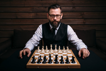 Male player against chess board with pieces set