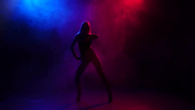 Silhouette girl pj is dancing in leather underwear, slow motion