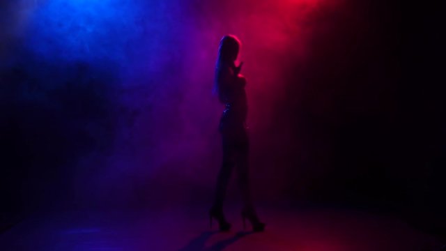 Silhouette girl pj is dancing in color smoke, slow motion