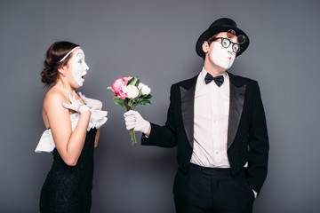 Pantomime actors performing with flower bouquet