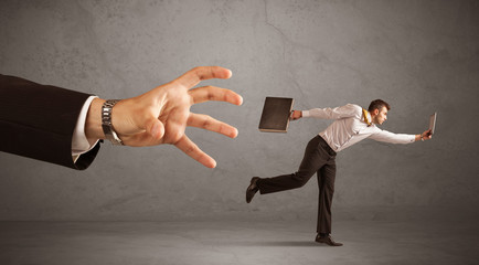 Businessman running from hand