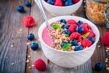 Breakfast smoothie bowl  with granola, fresh raspberry, blueberry, chia seeds and mint