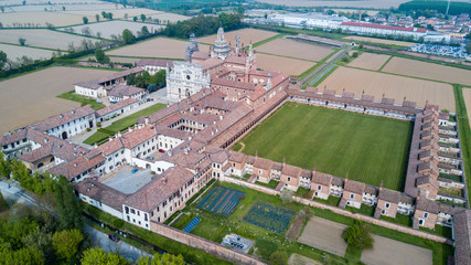 Vista aerea della Certosa di Pavia, costruita alla fine del XIV secolo,  campi e chiostro del monastero e santuario in provincia di Pavia, Lombardia, Italia