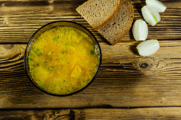 Vegetable soup in a glass bowl on wooden table. Top view