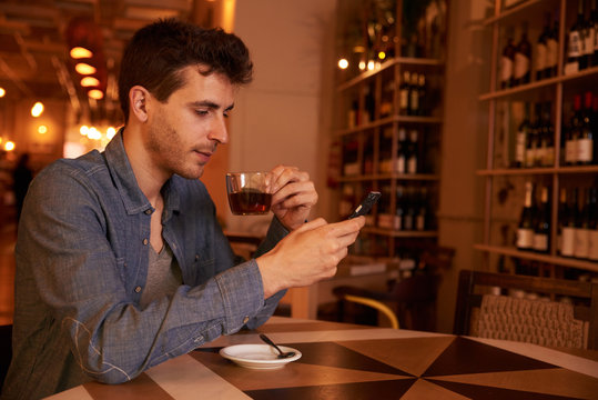 Charming millenial with tea in restaurant