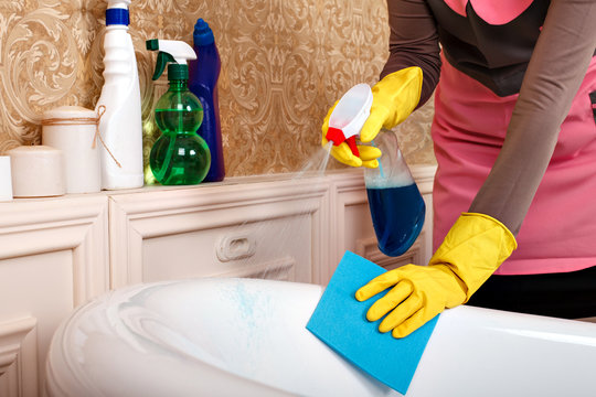Female hands in gloves cleans bathroom