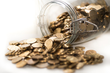 Glass jar full of shined Golden coins on the white background
