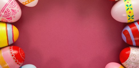 Various Easter eggs arranged on pink background