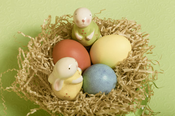 Easter symbols - colored eggs and bunny on light background. Toned
