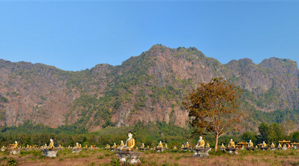 Panoramic view of the Garden of One Thousand Buddhas in Hpa-An, Myanmar. Mount Zwegabbin in the rays of the setting sun on the background.